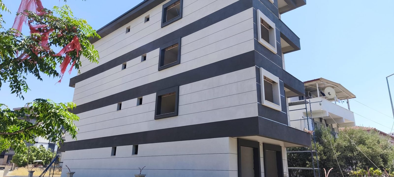 Beyaz ve antrasit çizgili apartman cephesi